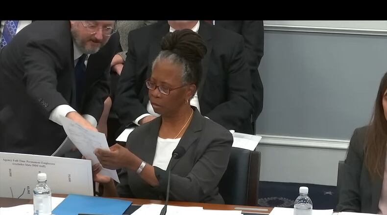 Tom Klouda, a deputy commissioner of the Social Security Administration, hands Kilolo Kijakazi, the agency’s acting commissioner, a piece of paper as she testifies at a House Ways and Means subcommittee hearing on Oct. 18 about the agency's payment clawbacks. (U.S. House Committee on Ways and Means)
