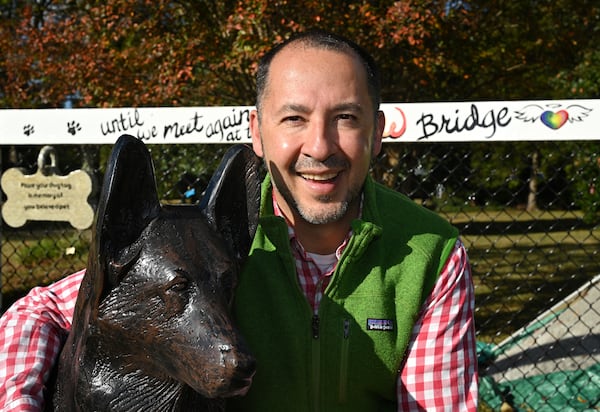 October 26, 2022 McDonough - Portrait of Dr. Humberto Fallas with a memorial of his German shepherd, Ace, near his office Fallas Family Vision in McDonough on Wednesday, October 26, 2022. The story is about a memorial that Dr. Humberto Fallas (called Peto) created for his German shepherd, Ace, that has become a kind of shrine for others who have lost their pets. About a dozen or so other pet owners have hung their pets' dogtags (and cat-tags) up at the site, memorializing animal friends who have passed away.(Hyosub Shin / Hyosub.Shin@ajc.com)