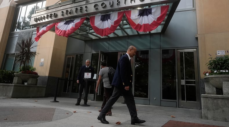 People walk outside of a Federal Courthouse Wednesday, Aug. 12, 2026, in Oakland, Calif. (AP Photo/Jeff Chiu)