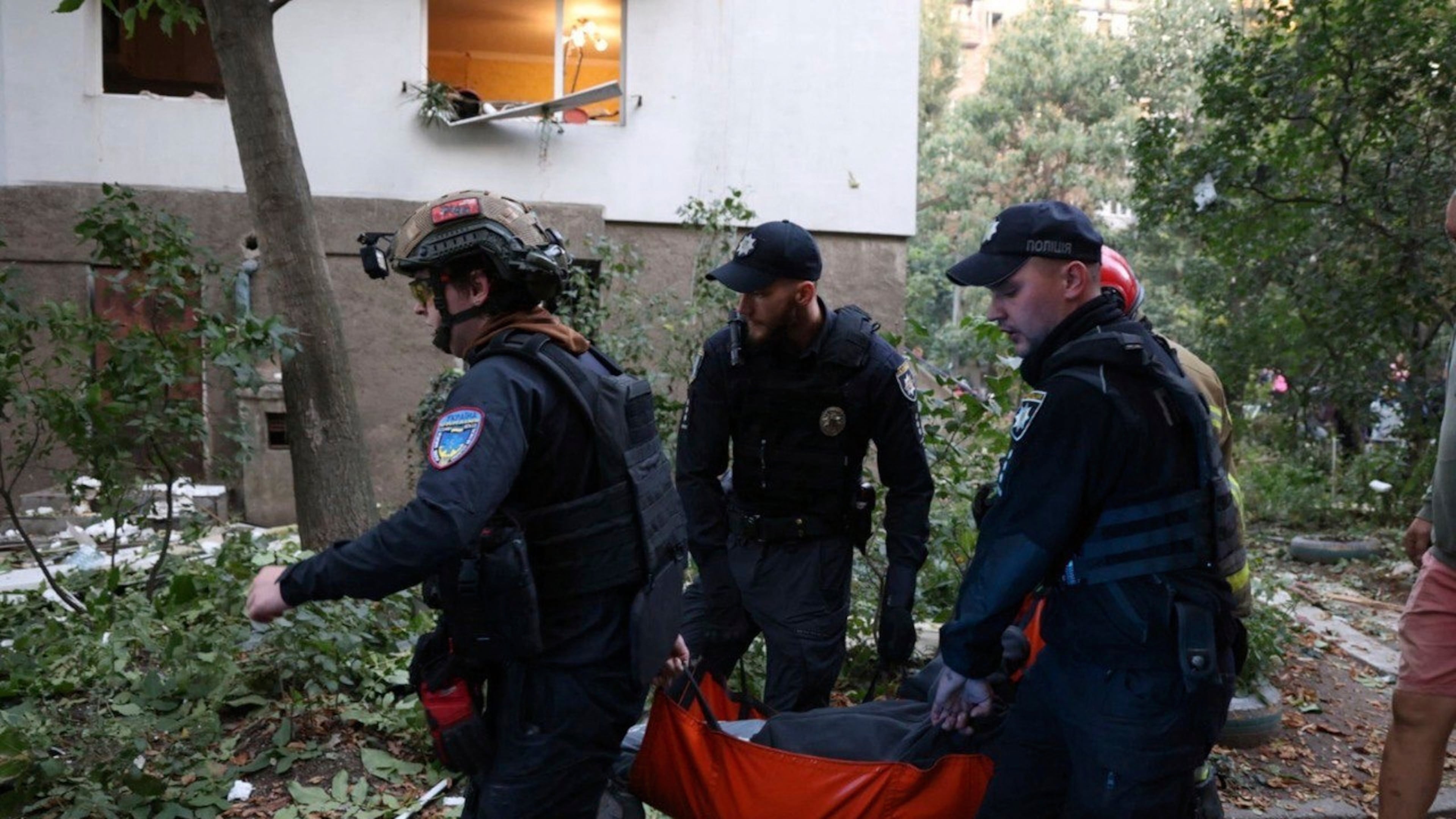 In this photo provided by the Ukrainian Emergency Services on Saturday, Sept. 20, 2025, policemen carry an injured person from a residential house damaged by a Russian strike on Dnipro, Ukraine. (Ukrainian Emergency Service via AP)
