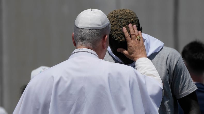 Pope Leo XIV blesses a migrant during a meeting with organisations working with migrants in Arguineguin at the Canary Islands, Spain, Thursday, June 11, 2026. (AP Photo/Alessandra Tarantino)
