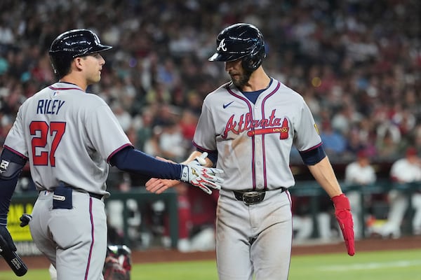 Atlanta Braves' Eli White, right, celebrates his run scored against the Arizona Diamondbacks with Braves' Austin Riley (27) during the fifth inning of a baseball game Sunday, April 27, 2025, in Phoenix. (AP Photo/Ross D. Franklin)