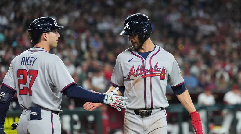 Atlanta Braves' Eli White, right, celebrates his run scored against the Arizona Diamondbacks with Braves' Austin Riley (27) during the fifth inning of a baseball game Sunday, April 27, 2025, in Phoenix. (AP Photo/Ross D. Franklin)
