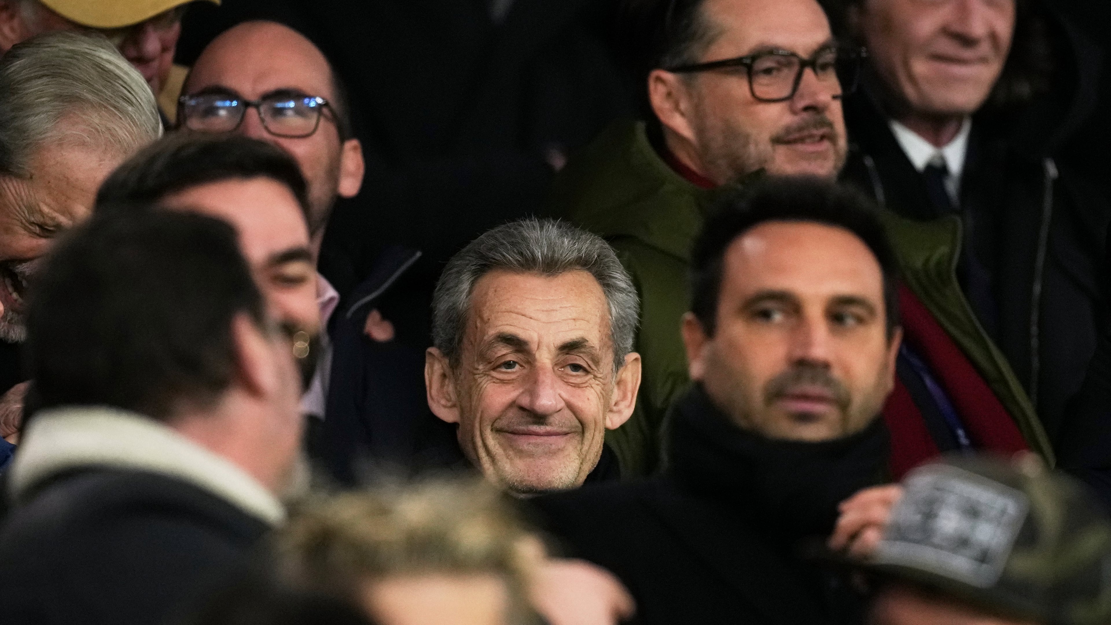 Former French President Nicolas Sarkozy, center, attends a Champions League opening phase soccer match between Paris Saint Germain and Tottenham, in Paris, Wednesday, Nov. 26, 2025. (AP Photo/Christophe Ena)