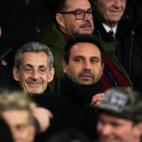 Former French President Nicolas Sarkozy, center, attends a Champions League opening phase soccer match between Paris Saint Germain and Tottenham, in Paris, Wednesday, Nov. 26, 2025. (AP Photo/Christophe Ena)