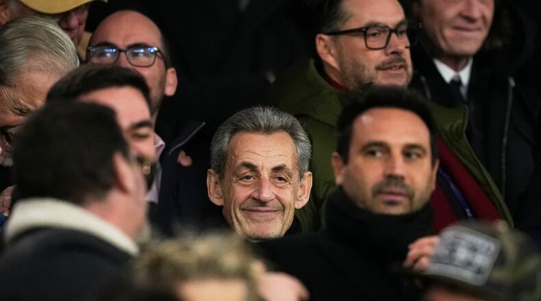 Former French President Nicolas Sarkozy, center, attends a Champions League opening phase soccer match between Paris Saint Germain and Tottenham, in Paris, Wednesday, Nov. 26, 2025. (AP Photo/Christophe Ena)