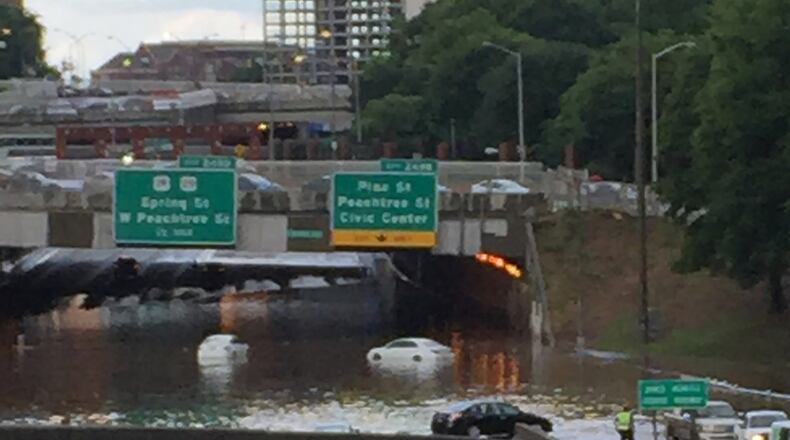 The Downtown Connector was flooded Sunday afternoon after an intense storm with high winds washed debris into the freeway drains and clogged them up. MONICA RICHARDSON / MRICHARDSON@AJC.COM