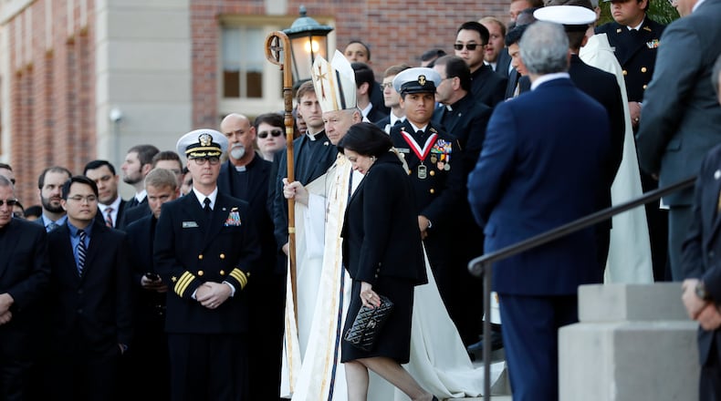 Gayle Benson, widow of Saints and Pelicans owner Tom Benson, walks down the steps to receive his casket with New Orleans Archbishop Gregory Aymond. Attorneys for several men suing the Roman Catholic Church say documents they obtained through discovery show that the Saints aided the Archdiocese of New Orleans in its "pattern and practice of concealing its crimes."