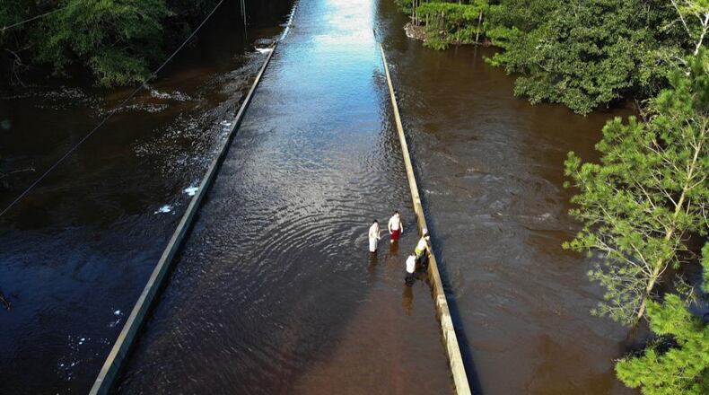 Hurricane Florence has left misery in its wake. People watch the flood waters rise as the Rockfish creek overflows a roadway on September 17, 2018 in Fayetteville, North Carolina. A dam burst in Anson County Monday evening and officials fear more are stressed after the deluge of rain from Florence.