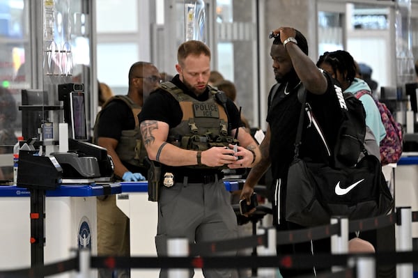 Immigration and Customs Enforcement agents work a TSA checkpoint at Hartsfield-Jackson Atlanta International Airport on Friday, March 27, 2026. Hartsfield-Jackson has been part of a reported increase in ICE agents at airports across the country. (Hyosub Shin/AJC)
