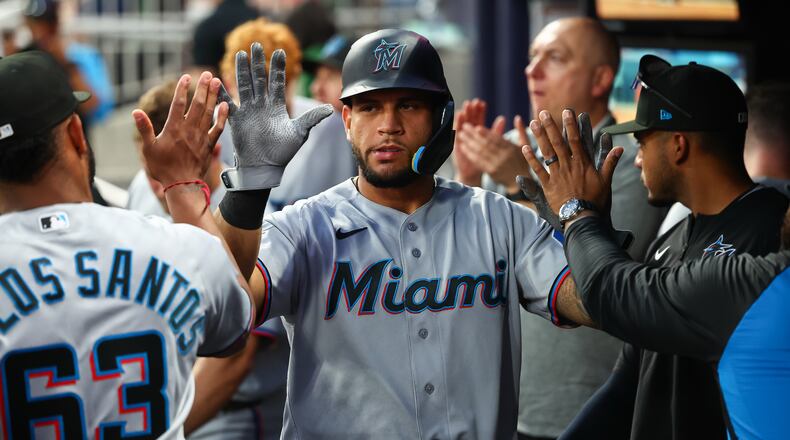 Miami Marlins' Agustín Ramírez, center, high-fives teammates in the dugout after scoring a run in the fourth inning of a baseball game against the Atlanta Braves, Monday, April 13, 2026, in Atlanta. (AP Photo/Colin Hubbard)