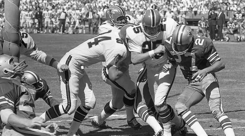 Falcons running back Junior Coffey reaches the end zone thanks to blocks by Verne Burke (84) and Alex Hawkins (25). AJC file photo
