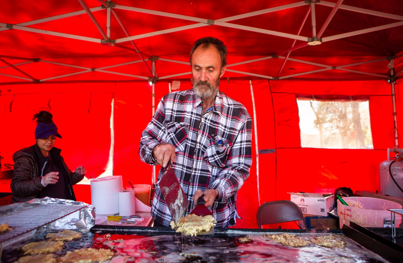 Lloyd Newcomb cooks latkes during Goethe Fruhlingsfest on Saturday, March 18, 2023, in Avondale Estates. CHRISTINA MATACOTTA FOR THE ATLANTA JOURNAL-CONSTITUTION. 