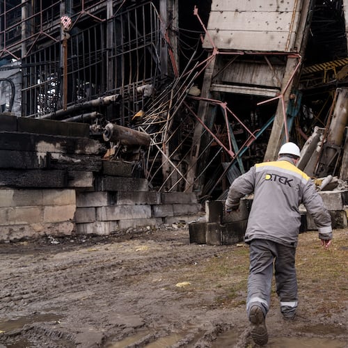 A worker walks in front of a production hall after a recent Russian missile attack at DTEK's power plant in Ukraine, on Wednesday, Dec. 10, 2025. (AP Photo/Evgeniy Maloletka)