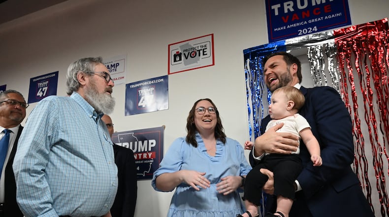 Republican vice presidential nominee JD Vance holds 10-month-old Emmalynn as her grandfather David Lowry (left) and mother Daelen Lowry (center) react. Vance was visiting the Trump campaign's Gwinnett County field office, Friday, October 11, 2024, in Lawrenceville. (Hyosub Shin / AJC)