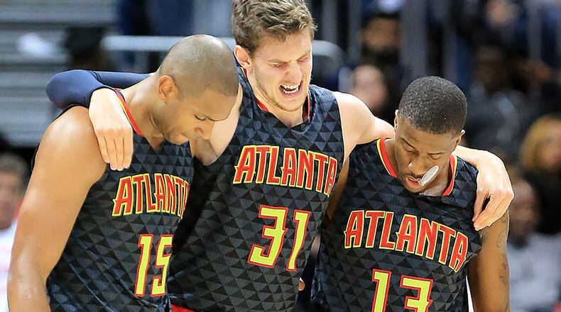 Hawks Al Horford (left) and Lamar Patterson (right) help Mike Muscala off the court after he was injured against the Pistrons during the second half in their first regular season basketball game "home opener" on Tuesday/ The Pistons beat the Hawks 106-94. Curtis Compton / ccompton@ajc.com