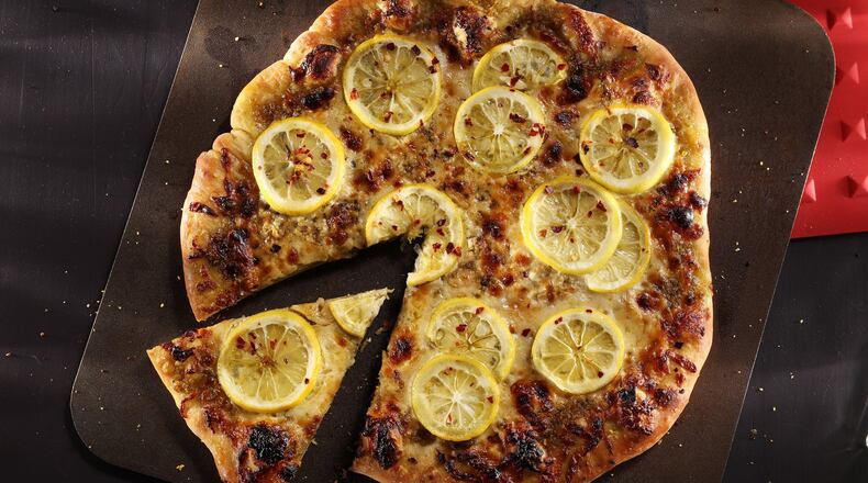 Pizza gets a smoky flavor from smoked mozzarella, which contrasts with sliced lemon and savory pesto. (Abel Uribe/Chicago Tribune/TNS)