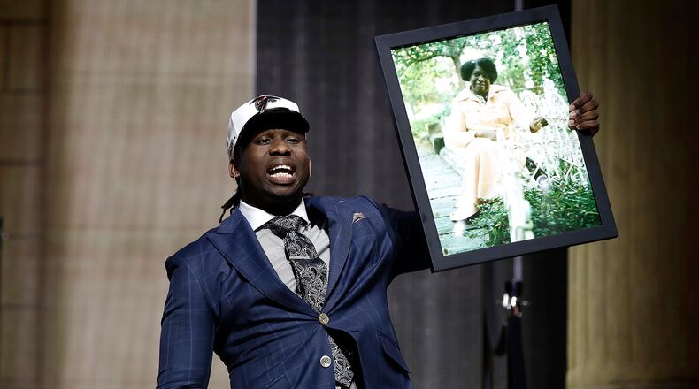 UCLA's Takkarist McKinley carries a photograph of his grandmother onstage after being selected by the Atlanta Falcons during the first round of the 2017 NFL football draft, Thursday, April 27, 2017, in Philadelphia.