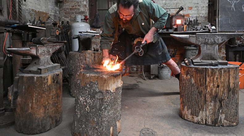 Mark Johnstone Hopper works on a metal leaf at his studio, Goat n Hammer, an Atlanta-based forge, complete with a few blacksmiths, a roaring fire and anvil. It's been quietly building a following for its bladesmithing and knife grinding instruction since 2013. Hyosub Shin / Hyosub.Shin@ajc.com
