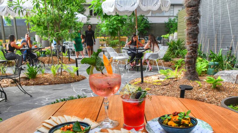 Among the offerings from Willow Bar at Kimpton Sylvan Hotel are, clockwise from top left: the Cypress G&T, Willow cocktail, charred cauliflower and cucumber avocado, beets and feta, and hummus. CHRIS HUNT FOR THE AJC