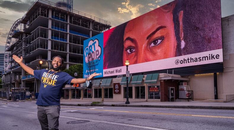 Michael Wall proudly shows his billboard near Centennial Park. 
Courtesy of Mark Alberhasky.