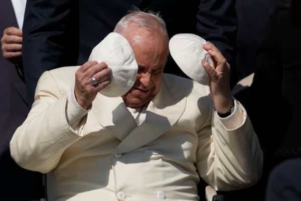 FILE - Pope Francis exchanges his skull cap with one presented by a participant in the weekly general audience in St. Peter's Square, at the Vatican, Wednesday, April 19, 2023. (AP Photo/Alessandra Tarantino, File)