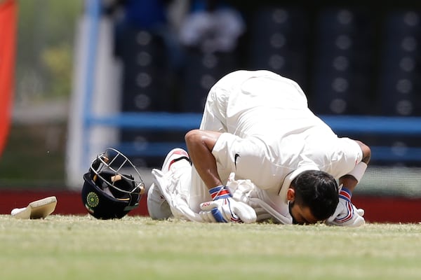 FILE - India's captain Virat Kohli kisses the field after scoring a double-century during day two of the first cricket Test match against West Indies at the Sir Vivian Richards Stadium in North Sound, Antigua, on July 22, 2016. (AP Photo/Ricardo Mazalan, File)
