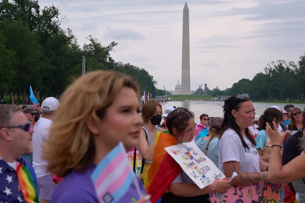 After marching with the National Trans Visibility March, Bella Bautista, 22, a transgender woman, attends the World Pride Rally on the National Mall, Sunday, June 8, 2025, with the Washington Monument in the background in Washington. (AP Photo/Jacquelyn Martin)