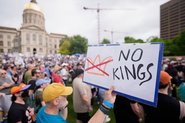 A demonstrator holds a sign during a "No Kings" protest, Saturday, June 14, 2025, in Atlanta. (AP Photo/Mike Stewart)