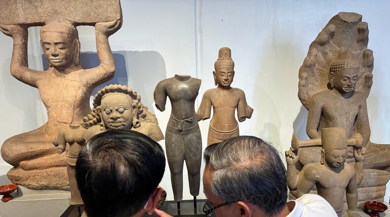 Cambodian officials look at Khmer cultural artifacts that were returned to the country, at the National Museum, in Phnom Penh, Friday, Feb. 27, 2026. (AP Photo/Sopheng Cheang)