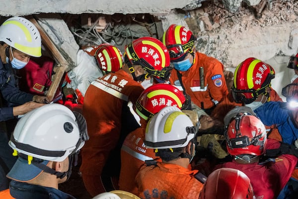 In this photo released by Xinhua News Agency, rescuers move a survivor out from a collapsed building in the aftermath of an earthquake in Mandalay, Myanmar, Monday, March 31, 2025. (Cai Yang/Xinhua via AP)
