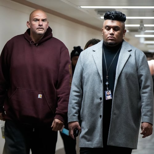 Injuries from a fall are seen on the face of Sen. John Fetterman, D-Pa., second from left, as he walks through a hallway on Capitol Hill, Wednesday, Nov. 19, 2025, in Washington. (AP Photo/Julia Demaree Nikhinson)
