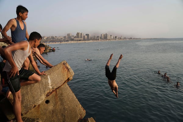 Palestinians jump into the water of the Mediterranean Sea to cool down during a heat wave in Gaza City, Saturday, May 17, 2025. (AP Photo/Jehad Alshrafi)