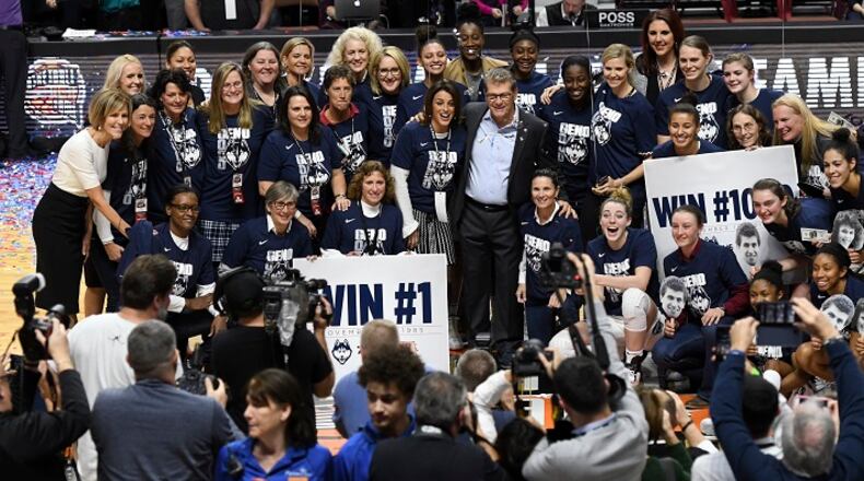 Connecticut head coach Geno Auriemma celebrates his 1,000th career victory with members of past and present players after an 88-64 win against Oklahoma at the Mohegan Sun Arena in Uncasville, Conn., on December 19, 2017. (John Woike/Hartford Courant/TNS)