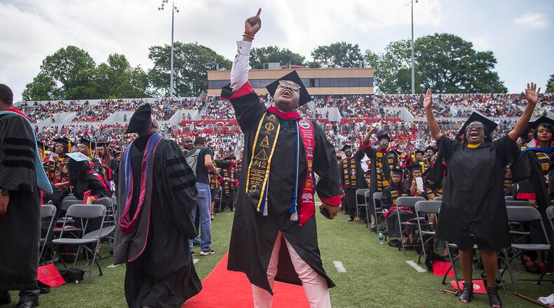 5/20/2019 -- Atlanta, Georgia -- Clark Atlanta University graduate Le'Zaire Reese (center) becomes emotional as a rendition the gospel song, "God is," is performed by The Clark Atlanta University Choirs during the 30th annual commencement ceremony at Panther Stadium in Atlanta, Monday, May 20, 2019. (Alyssa Pointer/alyssa.pointer@ajc.com)