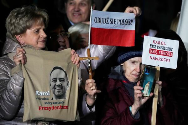 Supporters of conservative presidential candidate Karol Nawrocki hold up signs as they rally in Warsaw, Poland, Tuesday, May 13, 2025. The writing reads: Karol, the man who will become president, Wake up, Poland! and Our president Karol Nawrocki. (AP Photo/Czarek Sokolowski)