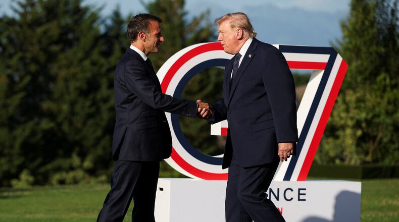French President Emmanuel Macron greets President Donald Trump, right, during the official arrivals ceremony for the G7 summit in Evian-les-Bains, France, Monday, June 15, 2026. (Isabel Infantes, Pool Photo via AP)