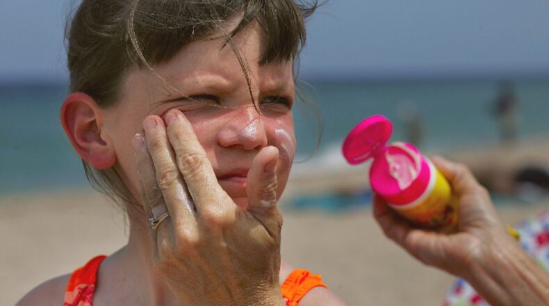 Sharon Doyle puts sunscreen on the face of 9-year-old Savannah Stidham as they visit the beach June 20, 2006 in Fort Lauderdale, Florida.