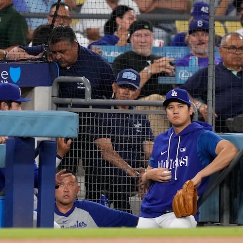 Los Angeles Dodgers' Shohei Ohtani watches from the dugout during the first inning of a baseball game against the Cincinnati Reds, Tuesday, Sept. 8, 2026, in Los Angeles. (AP Photo/Mark J. Terrill)