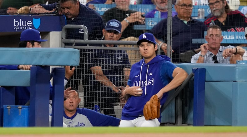 Los Angeles Dodgers' Shohei Ohtani watches from the dugout during the first inning of a baseball game against the Cincinnati Reds, Tuesday, Sept. 8, 2026, in Los Angeles. (AP Photo/Mark J. Terrill)