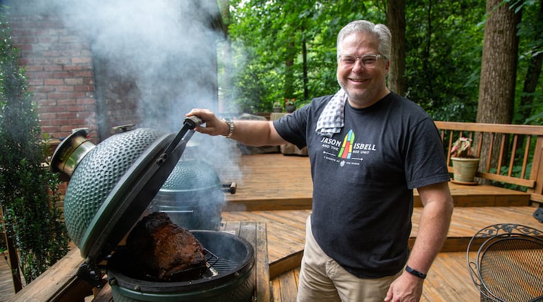 Hal Boyd cooks smoked pork on his Big Green Egg to make pulled pork sandwiches for healthcare workers at Piedmont Hospital at his North Druid Hills Home. He and his friends have made and delivered more than 4,000 BBQ sandwiches to area hospitals and other first responders since the pandemic began. PHIL SKINNER FOR THE ATLANTA JOURNAL-CONSTITUTION.