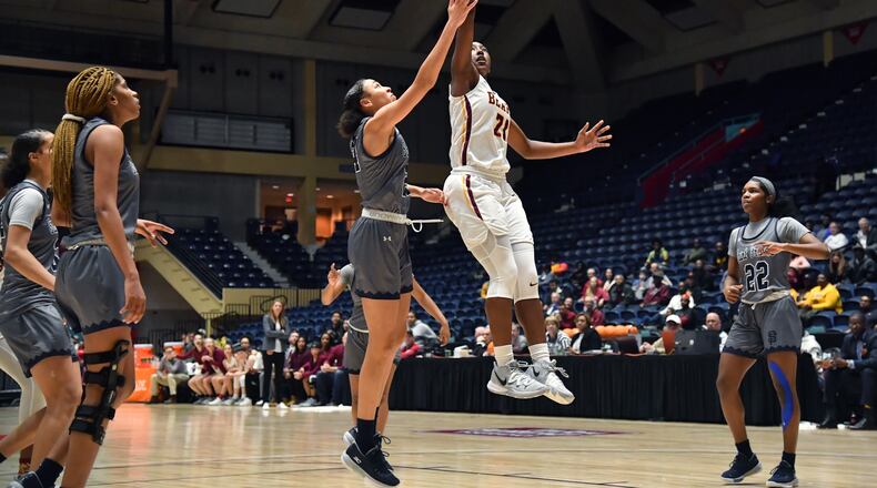 Holy Innocents' Olivia Hutcherson (21) goes to the basket past St. Francis' Savannah Samuel (24). (Hyosub Shin / Hyosub.Shin@ajc.com)