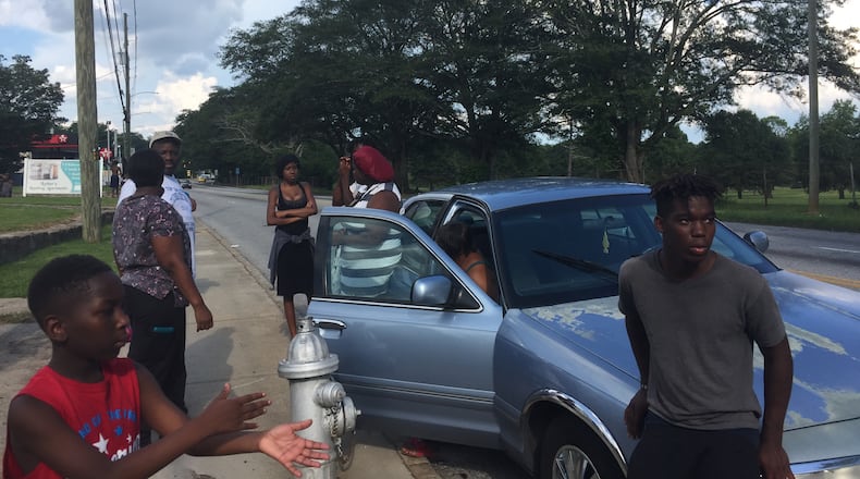 Family and friends of 18-year-old Markeith Oliver await information as they gather on Martin Luther King Jr. Drive on Friday afternoon. J.D. CAPELOUTO