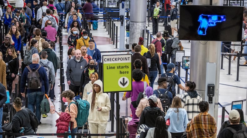 Travelers stand in line to go through the security checkpoint at Hartsfield-Jackson Atlanta International Airport during a busy Friday morning, October 28, 2022. (Steve Schaefer/steve.schaefer@ajc.com)