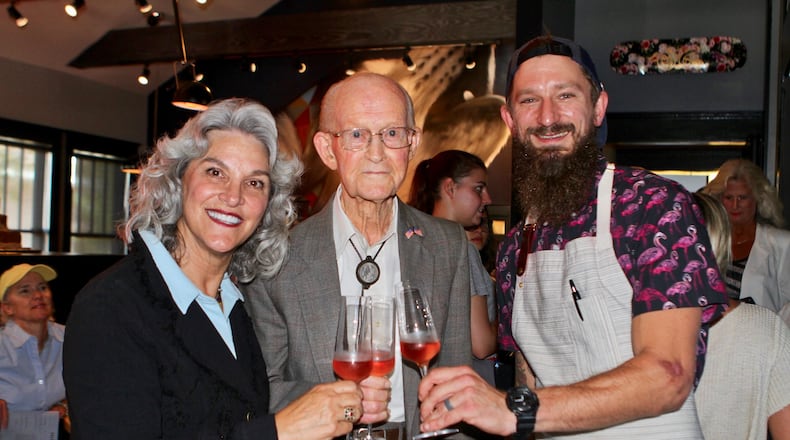 Cheri Morris, the developer of the new Alpharetta City Center, George Jones and chef Taylor Neary toast opening night of Restaurant Holmes in Alpharetta. Jones, 97, grew up in the bungalow turned restaurant. CONTRIBUTED BY DIANE MAICON