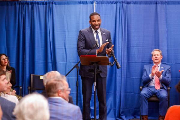 Atlanta Mayor Andre Dickens, with Gov. Brian Kemp seated, speaks during a press conference marking the opening of the affordable housing and transitional program run by Georgia Works in the Historic Odd Fellows building in Atlanta on April 1, 2026. (Arvin Temkar/AJC)