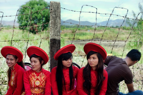FILE- Attendants sit next to a field contaminated with dioxin before a ceremony marking the start of a project to clean up dioxin left over from the Vietnam War, at a former U.S. military base in Danang, Vietnam Thursday Aug. 9, 2012. (AP Photo/Maika Elan, File)
