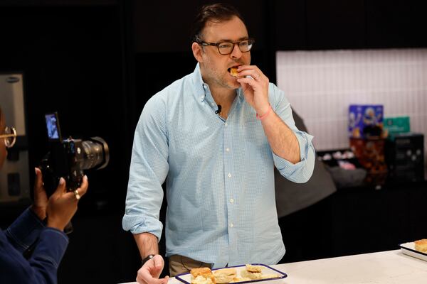 AJC restaurant critic Henri Holis is seen taking a bite of a biscuit during a tasting contest to find the best biscuit in Atlanta on Tuesday, April 28, 2026. (Miguel Martinez/AJC)