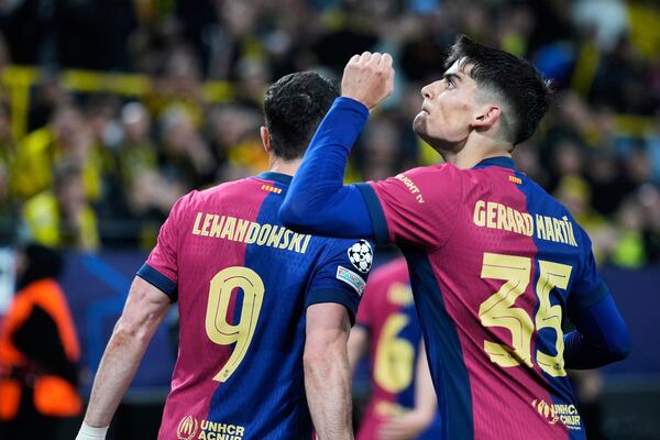 Barcelona's Gerard Martin celebrates after forcing an own goal by Dortmund's Ramy Bensebaini during the Champions League quarterfinals second leg soccer match between Borussia Dortmund and Barcelona, at the Signa-Iduna Park in Dortmund, Germany, Tuesday, April 15, 2025. (AP Photo/Matthias Schrader)