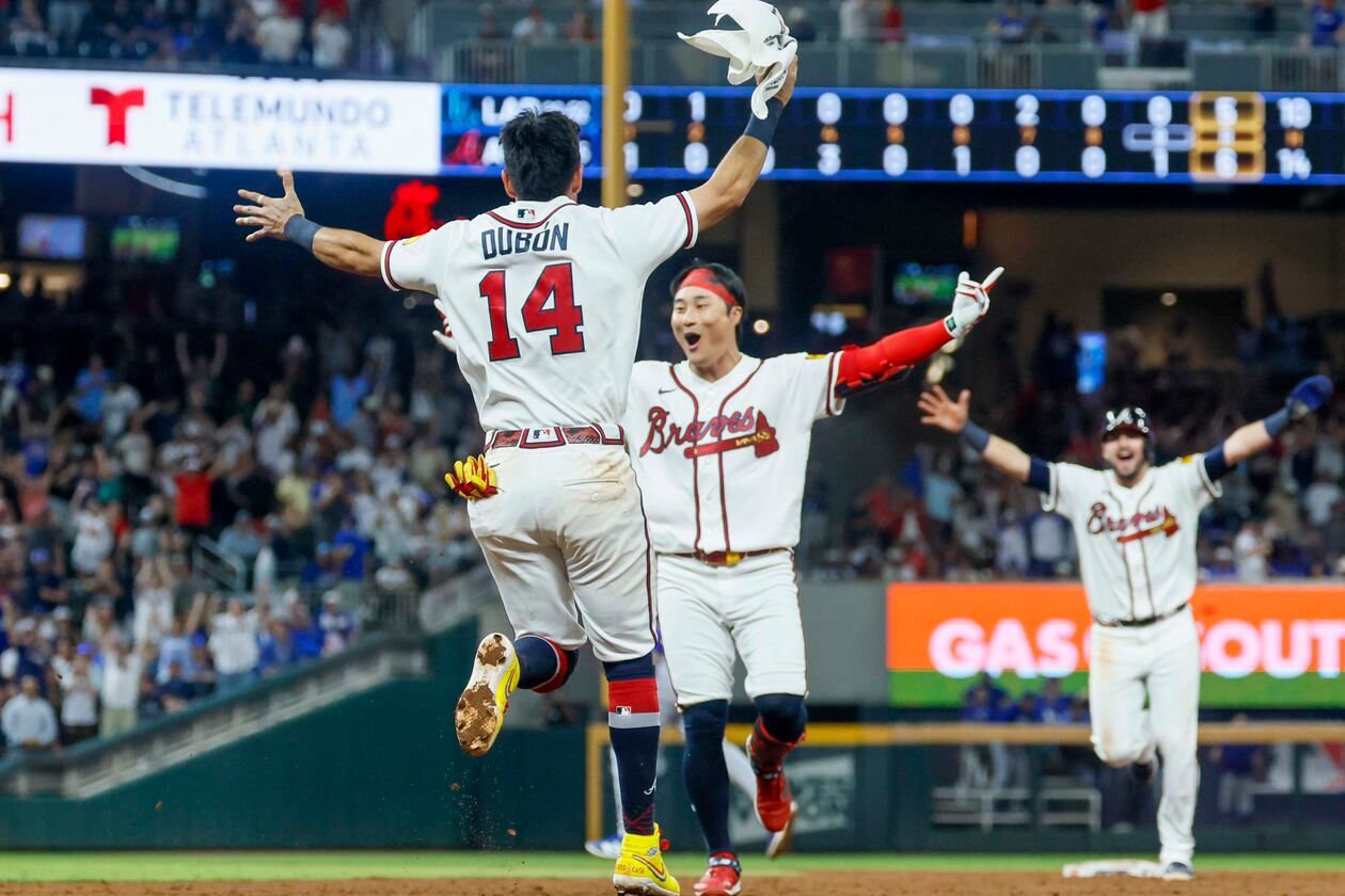 Atlanta Braves left fielder Mauricio Dubón (left) runs to celebrate with teammate Ha-Seong Kim after Kim hit a walk-off single in the ninth inning against the Los Angeles Dodgers at Truist Park in Atlanta on Wednesday, Aug. 26, 2026. The Braves defeated the Dodgers 6-5. (Miguel Martinez/AJC)